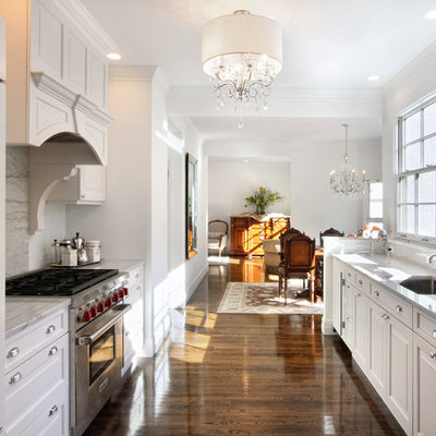 Example of a classic galley medium tone wood floor eat-in kitchen design in New York with an undermount sink, recessed-panel cabinets, white cabinets, marble countertops, gray backsplash, paneled appliances and marble backsplash