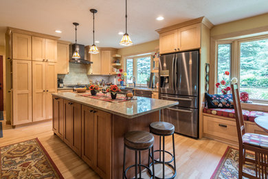 Large elegant l-shaped light wood floor and brown floor eat-in kitchen photo in Minneapolis with a farmhouse sink, shaker cabinets, light wood cabinets, granite countertops, beige backsplash, subway tile backsplash, stainless steel appliances, an island and brown countertops