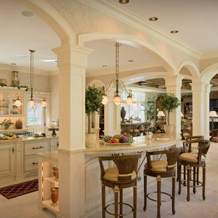 Design ideas for a large victorian l-shaped open plan kitchen in Houston with a drop-in sink, raised-panel cabinets, white cabinets, quartz benchtops, white splashback, subway tile splashback, stainless steel appliances, porcelain floors and multiple islands.