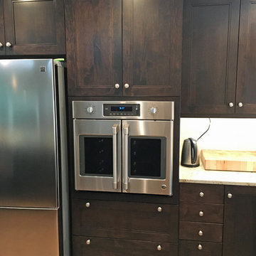Rich dark stain on custom maple cabinets by Wood-Mode.  Custom tall oven cabinet