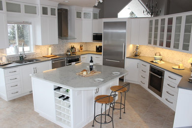 Large transitional u-shaped vinyl floor and multicolored floor eat-in kitchen photo in Edmonton with an undermount sink, shaker cabinets, white cabinets, quartz countertops, multicolored backsplash, marble backsplash, stainless steel appliances and an island