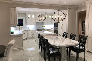Eat-in kitchen - huge traditional u-shaped white floor eat-in kitchen idea in Toronto with an undermount sink, recessed-panel cabinets, distressed cabinets, quartz countertops, white backsplash, marble backsplash, paneled appliances, an island and white countertops