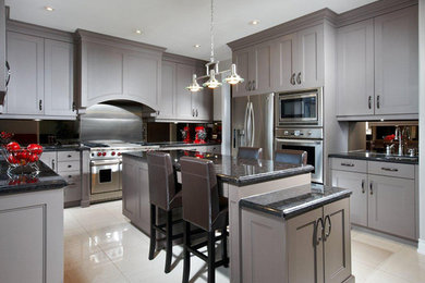Mid-sized minimalist u-shaped porcelain tile and beige floor eat-in kitchen photo in Toronto with gray cabinets, granite countertops, stainless steel appliances, an island, a single-bowl sink, shaker cabinets and mirror backsplash