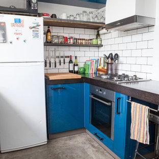 Imagen de cocina moderna con armarios con paneles lisos, puertas de armario azules, salpicadero blanco, salpicadero de azulejos tipo metro y electrodomésticos blancos