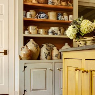 Design ideas for a small country u-shaped separate kitchen in Atlanta with a farmhouse sink, beaded inset cabinets, distressed cabinets, soapstone benchtops, black splashback, stone slab splashback, stainless steel appliances, brick floors and with island.