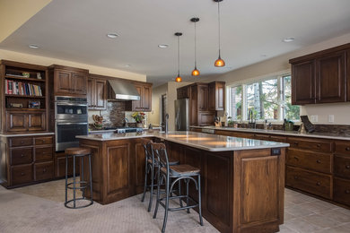 Example of a large classic l-shaped ceramic tile eat-in kitchen design in Boise with a drop-in sink, raised-panel cabinets, medium tone wood cabinets, stainless steel appliances and an island