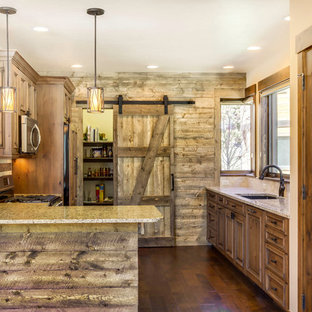 Idee per una piccola cucina ad U rustica chiusa con lavello sottopiano, ante con riquadro incassato, ante in legno scuro, top alla veneziana, paraspruzzi beige, paraspruzzi con piastrelle in pietra, elettrodomestici in acciaio inossidabile, pavimento in legno massello medio e penisola