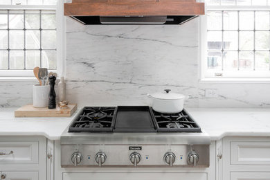 Inspiration for a large timeless medium tone wood floor kitchen remodel in Other with flat-panel cabinets, white cabinets, marble countertops, white backsplash, marble backsplash, stainless steel appliances, an island and an undermount sink