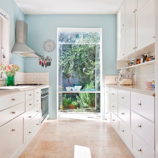 Design ideas for a mid-sized scandinavian galley separate kitchen in Melbourne with a double-bowl sink, white cabinets, quartzite benchtops, white splashback, ceramic splashback, stainless steel appliances, travertine floors, no island and shaker cabinets.