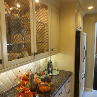 Photo of a mid-sized mediterranean u-shaped eat-in kitchen in San Francisco with a single-bowl sink, glass-front cabinets, white cabinets, quartz benchtops, beige splashback, stone tile splashback, panelled appliances, porcelain floors and with island.