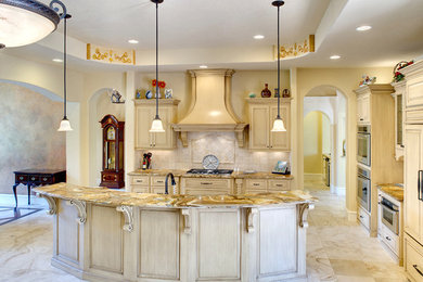 Example of a tuscan galley eat-in kitchen design in Austin with an undermount sink, raised-panel cabinets, white cabinets, beige backsplash, ceramic backsplash and stainless steel appliances