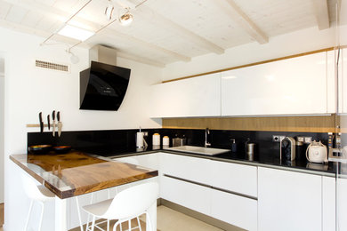 Foto de cocinas en U actual de tamaño medio cerrado con suelo de madera en tonos medios y península