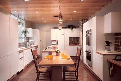 Inspiration for a modern galley open concept kitchen remodel in Philadelphia with a triple-bowl sink, flat-panel cabinets, yellow cabinets, multicolored backsplash, ceramic backsplash and paneled appliances