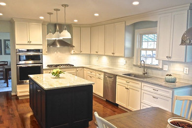 Inspiration for a large transitional dark wood floor kitchen remodel in Baltimore with an undermount sink, shaker cabinets, white cabinets, granite countertops, white backsplash, glass tile backsplash, stainless steel appliances and an island