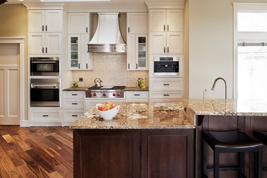 Kitchen pantry - large transitional medium tone wood floor kitchen pantry idea in Calgary with an undermount sink, shaker cabinets, granite countertops, multicolored backsplash, stone tile backsplash, stainless steel appliances, an island and dark wood cabinets