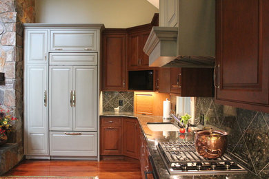 Example of a large transitional l-shaped dark wood floor and brown floor eat-in kitchen design in Richmond with an undermount sink, raised-panel cabinets, medium tone wood cabinets, granite countertops, gray backsplash, stone tile backsplash, paneled appliances and no island