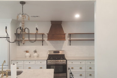 Mid-sized country u-shaped dark wood floor and brown floor eat-in kitchen photo in Dallas with recessed-panel cabinets, white cabinets, quartz countertops, white backsplash, stainless steel appliances, an island and an undermount sink