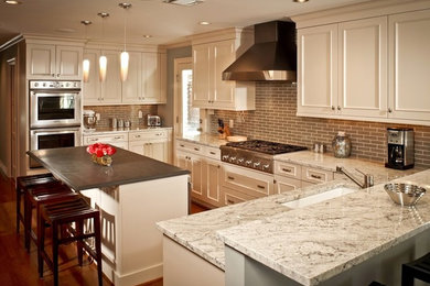 Example of a large transitional u-shaped medium tone wood floor eat-in kitchen design in Cincinnati with a single-bowl sink, recessed-panel cabinets, white cabinets, granite countertops, gray backsplash, glass tile backsplash, stainless steel appliances and an island
