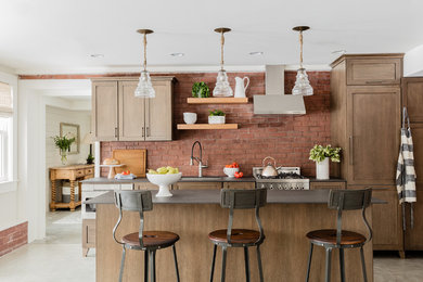 Inspiration for a coastal concrete floor enclosed kitchen remodel in Boston with an undermount sink, shaker cabinets, dark wood cabinets, red backsplash, brick backsplash, stainless steel appliances, an island and black countertops