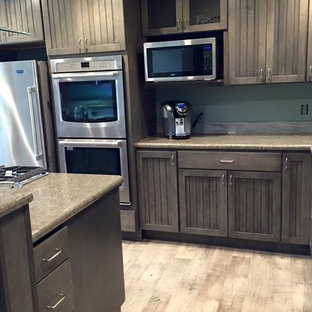 Mid-sized shabby-chic style l-shaped eat-in kitchen in Other with an undermount sink, shaker cabinets, grey cabinets, laminate benchtops, blue splashback, mosaic tile splashback, stainless steel appliances, vinyl floors and with island.