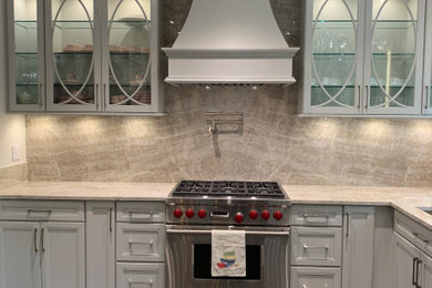 Example of a mid-sized transitional l-shaped marble floor and black floor enclosed kitchen design in New York with an undermount sink, flat-panel cabinets, gray cabinets, quartzite countertops, beige backsplash, stone slab backsplash, stainless steel appliances, a peninsula and beige countertops