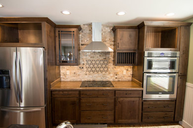 Open concept kitchen - small craftsman single-wall vinyl floor open concept kitchen idea in Other with an undermount sink, recessed-panel cabinets, medium tone wood cabinets, solid surface countertops, multicolored backsplash, stone tile backsplash, stainless steel appliances and an island