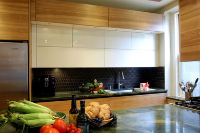 Bild på ett litet funkis kök, med en undermonterad diskho, släta luckor, vita skåp, rostfria vitvaror, mellanmörkt trägolv, en köksö, marmorbänkskiva, svart stänkskydd och stänkskydd i keramik