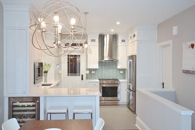 Example of a transitional kitchen design in Chicago with an undermount sink, white cabinets, quartz countertops, blue backsplash, glass tile backsplash and stainless steel appliances