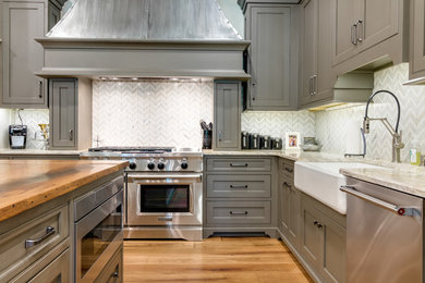 Inspiration for a classic kitchen/diner in Little Rock with a belfast sink, beaded cabinets, wood worktops, white splashback, stainless steel appliances, light hardwood flooring, an island and yellow floors.