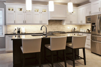 Example of a mid-sized transitional l-shaped porcelain tile eat-in kitchen design in Toronto with an undermount sink, recessed-panel cabinets, white cabinets, granite countertops, beige backsplash, stone tile backsplash, stainless steel appliances and an island