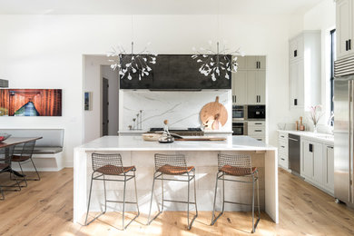 Eat-in kitchen - country u-shaped medium tone wood floor and brown floor eat-in kitchen idea in Austin with shaker cabinets, white cabinets, white backsplash, stainless steel appliances and an island
