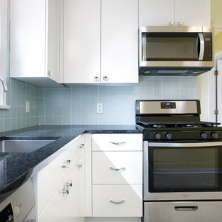 Design ideas for a small midcentury l-shaped separate kitchen in Minneapolis with an undermount sink, flat-panel cabinets, white cabinets, granite benchtops, blue splashback, ceramic splashback, stainless steel appliances, vinyl floors, no island, grey floor and black benchtop.