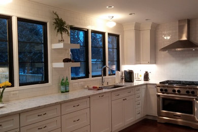 Transitional kitchen photo in Detroit with recessed-panel cabinets, white cabinets, solid surface countertops, white backsplash, subway tile backsplash and stainless steel appliances