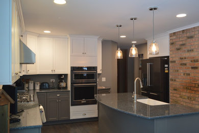 Example of a large transitional l-shaped dark wood floor eat-in kitchen design in Chicago with a farmhouse sink, shaker cabinets, white cabinets, quartz countertops, black appliances and an island