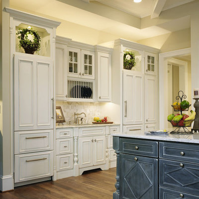 Eat-in kitchen - huge traditional l-shaped dark wood floor and brown floor eat-in kitchen idea in Baltimore with a farmhouse sink, beaded inset cabinets, white cabinets, granite countertops, beige backsplash, stone slab backsplash, stainless steel appliances and an island