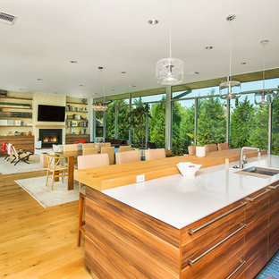 Inspiration for a mid-sized midcentury galley open plan kitchen in Dallas with an undermount sink, flat-panel cabinets, medium wood cabinets, quartz benchtops, beige splashback, brick splashback, stainless steel appliances, light hardwood floors, with island, beige floor and white benchtop.