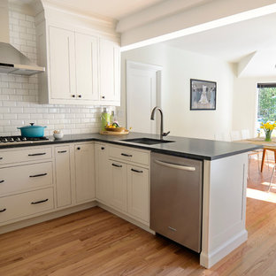 Inspiration for a small traditional u-shaped eat-in kitchen in New York with an undermount sink, shaker cabinets, beige cabinets, granite benchtops, white splashback, ceramic splashback, stainless steel appliances and a peninsula.