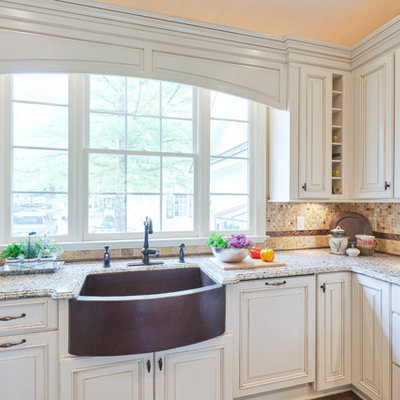 Inspiration for a large timeless u-shaped medium tone wood floor and brown floor eat-in kitchen remodel in Atlanta with raised-panel cabinets, a farmhouse sink, white cabinets, granite countertops, multicolored backsplash, travertine backsplash, stainless steel appliances, a peninsula and beige countertops