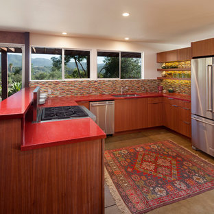 Design ideas for a mid-sized midcentury u-shaped eat-in kitchen in Los Angeles with an undermount sink, flat-panel cabinets, medium wood cabinets, quartz benchtops, multi-coloured splashback, glass tile splashback, stainless steel appliances, concrete floors, a peninsula and red benchtop.