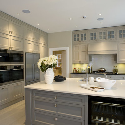 Inspiration for a transitional kitchen remodel in London with an undermount sink, recessed-panel cabinets, gray cabinets, white backsplash and stainless steel appliances