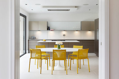 Medium sized contemporary galley kitchen/diner in London with flat-panel cabinets, brown cabinets, quartz worktops, integrated appliances, an island, grey floors and white splashback.