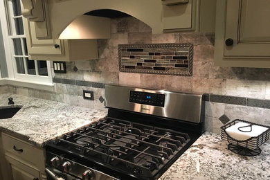 Example of a mid-sized classic l-shaped medium tone wood floor enclosed kitchen design in Atlanta with an undermount sink, beaded inset cabinets, white cabinets, granite countertops, beige backsplash, stone tile backsplash, black appliances and an island