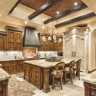 Inspiration for a large mediterranean u-shaped eat-in kitchen in Phoenix with a double-bowl sink, recessed-panel cabinets, dark wood cabinets, recycled glass benchtops, white splashback, porcelain splashback, stainless steel appliances, travertine floors and with island.