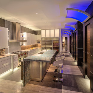 Foto di una cucina design con lavello sottopiano, ante bianche, top in vetro riciclato, paraspruzzi nero, paraspruzzi con piastrelle di metallo e elettrodomestici in acciaio inossidabile