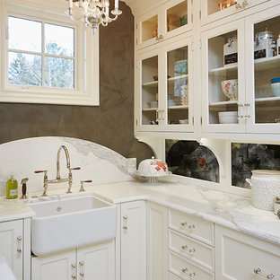 Inspiration for a small traditional u-shaped kitchen pantry in Grand Rapids with a farmhouse sink, glass-front cabinets, white cabinets, marble benchtops, white splashback, porcelain splashback, panelled appliances, multi-coloured benchtop, ceramic floors, no island and multi-coloured floor.