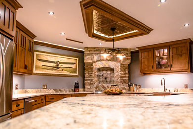 Large arts and crafts u-shaped brown floor and porcelain tile open concept kitchen photo in Other with medium tone wood cabinets, granite countertops, stone tile backsplash, two islands, an undermount sink, shaker cabinets, brown backsplash and stainless steel appliances