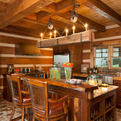 Open concept kitchen - large rustic l-shaped brick floor open concept kitchen idea in Other with a farmhouse sink, medium tone wood cabinets, glass countertops, brown backsplash, stainless steel appliances and an island
