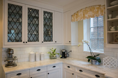 Eat-in kitchen - large traditional l-shaped slate floor eat-in kitchen idea in Toronto with a farmhouse sink, white cabinets, marble countertops, white backsplash, subway tile backsplash, stainless steel appliances, an island and shaker cabinets