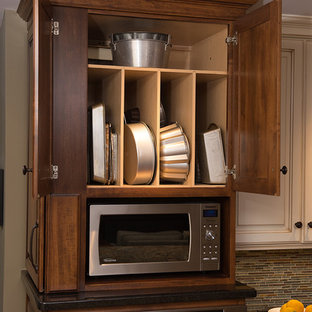 Large traditional open plan kitchen in Chicago with a double-bowl sink, raised-panel cabinets, granite benchtops, multi-coloured splashback, glass tile splashback, stainless steel appliances, medium hardwood floors, with island and medium wood cabinets.