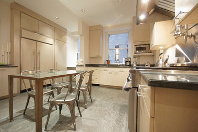Example of a minimalist l-shaped concrete floor and gray floor kitchen design in New York with an undermount sink, flat-panel cabinets, beige cabinets, granite countertops, beige backsplash, paneled appliances and no island